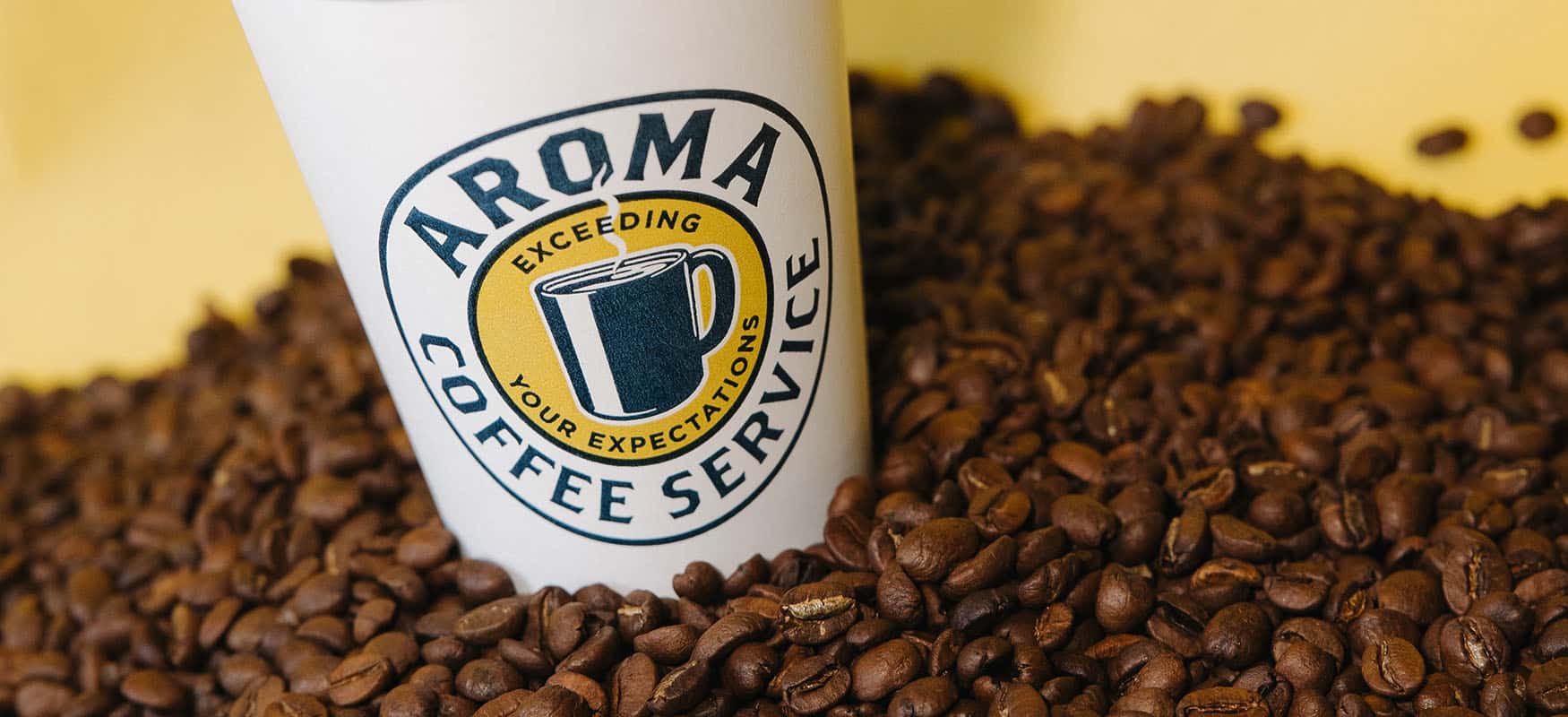 Aroma Coffee Cup in a pile of beans.
